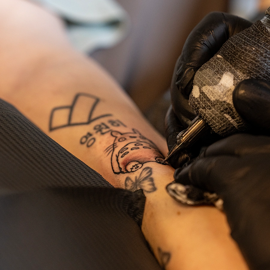 Bewohnerin wird in ihrem Bett tattowiert.