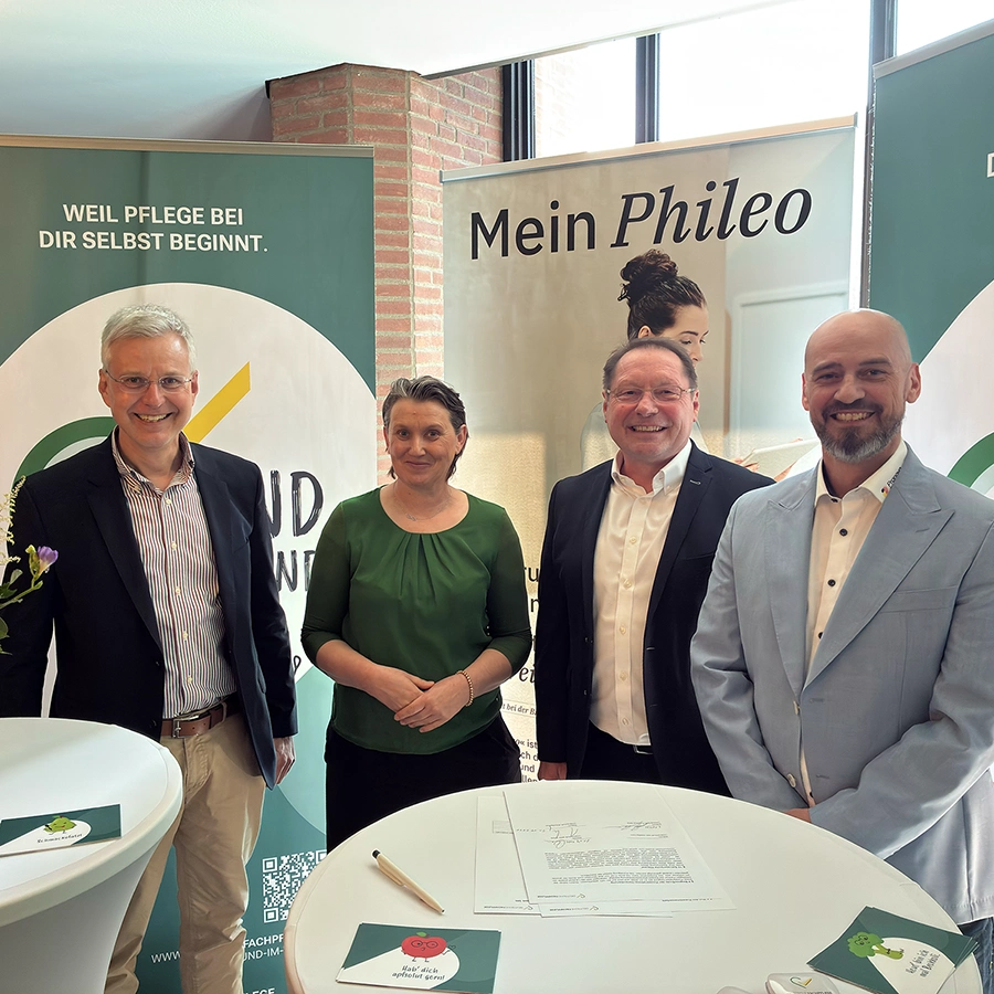 4 Personen stehen auf dem Messestand der DFund lächeln in die Kamara