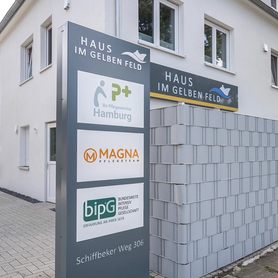 Außenaufnahme von dem WG-Gebäude und im Vordergrund die Beschilderung